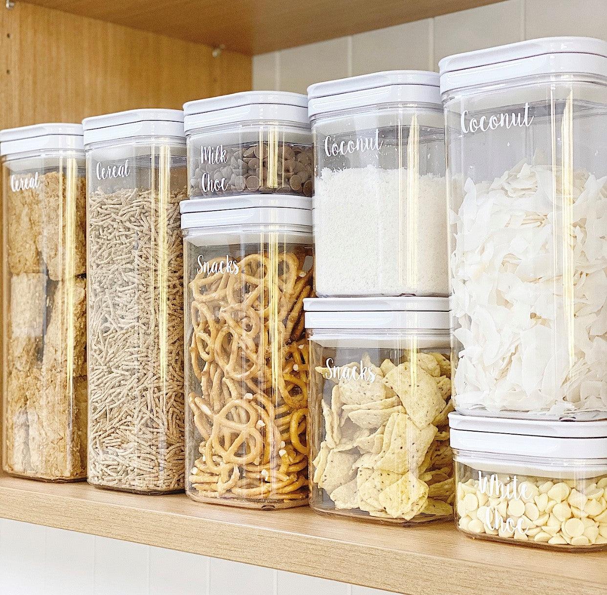 White flip canister storing cereals, snacks, and coconut flakes.
